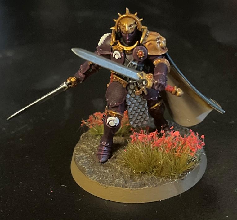 A toy figurine of a warrior holding a sword Description automatically generated