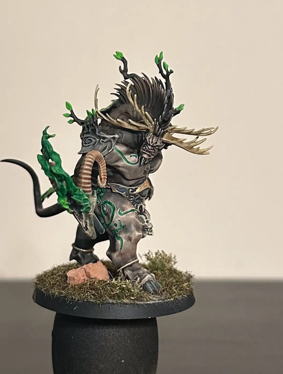 A statue of a creature with horns and a snake Description automatically generated
