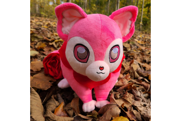 The Rose Possum plush in a feild of leaves