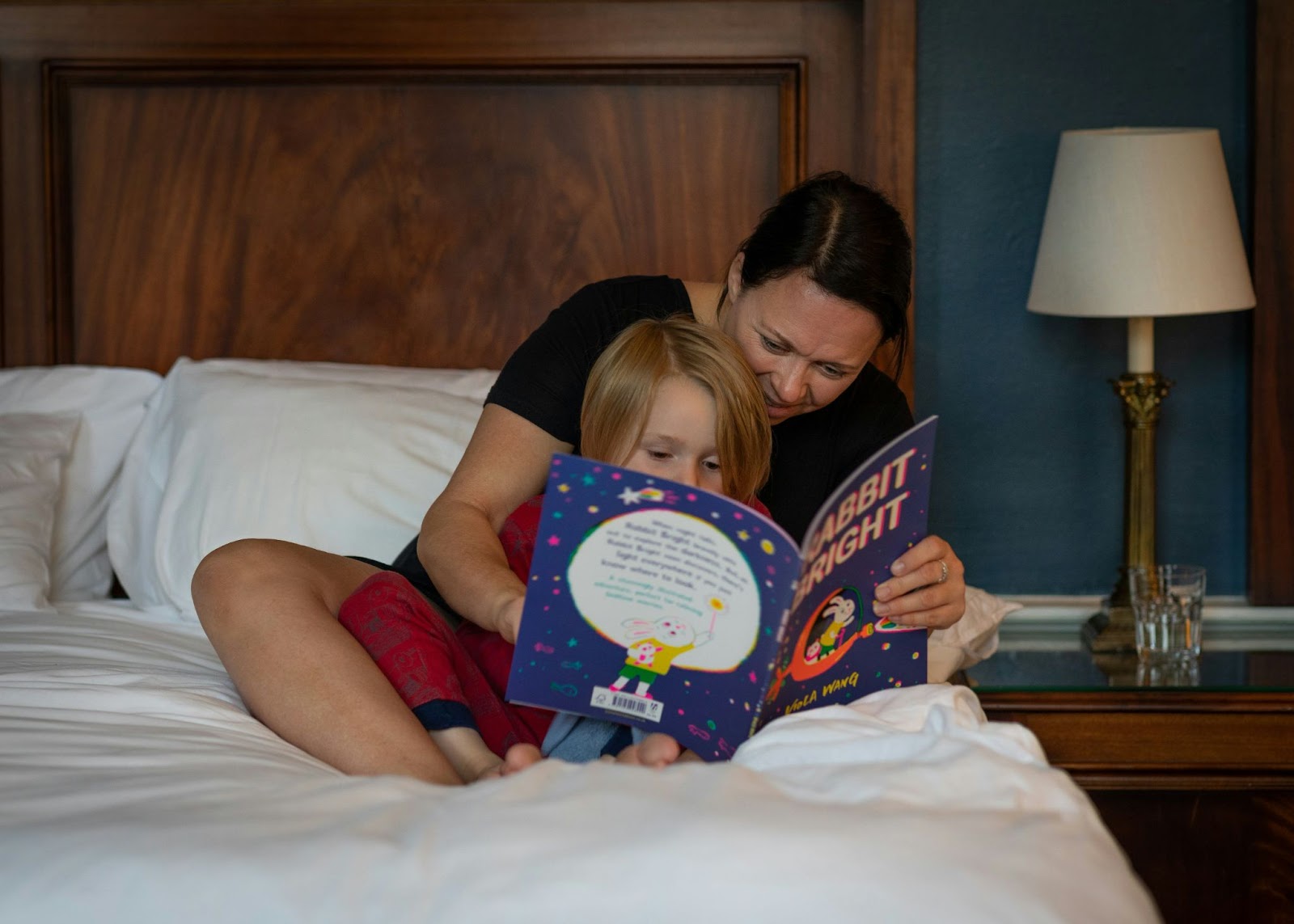 A mother reading a book to her child before bedtime