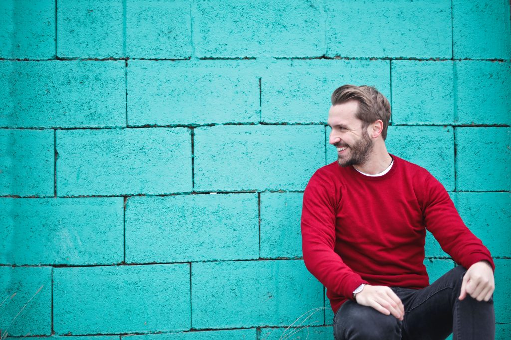 Is your coaching price too cheap? Man sitting against blue wall