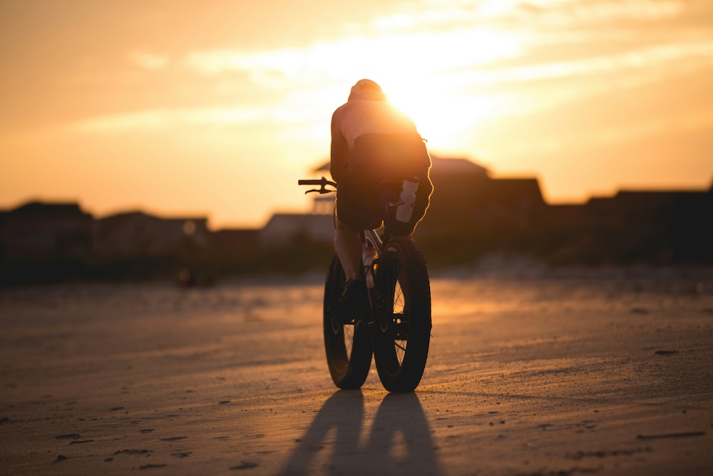 Biker riding along the beach in Oak Island