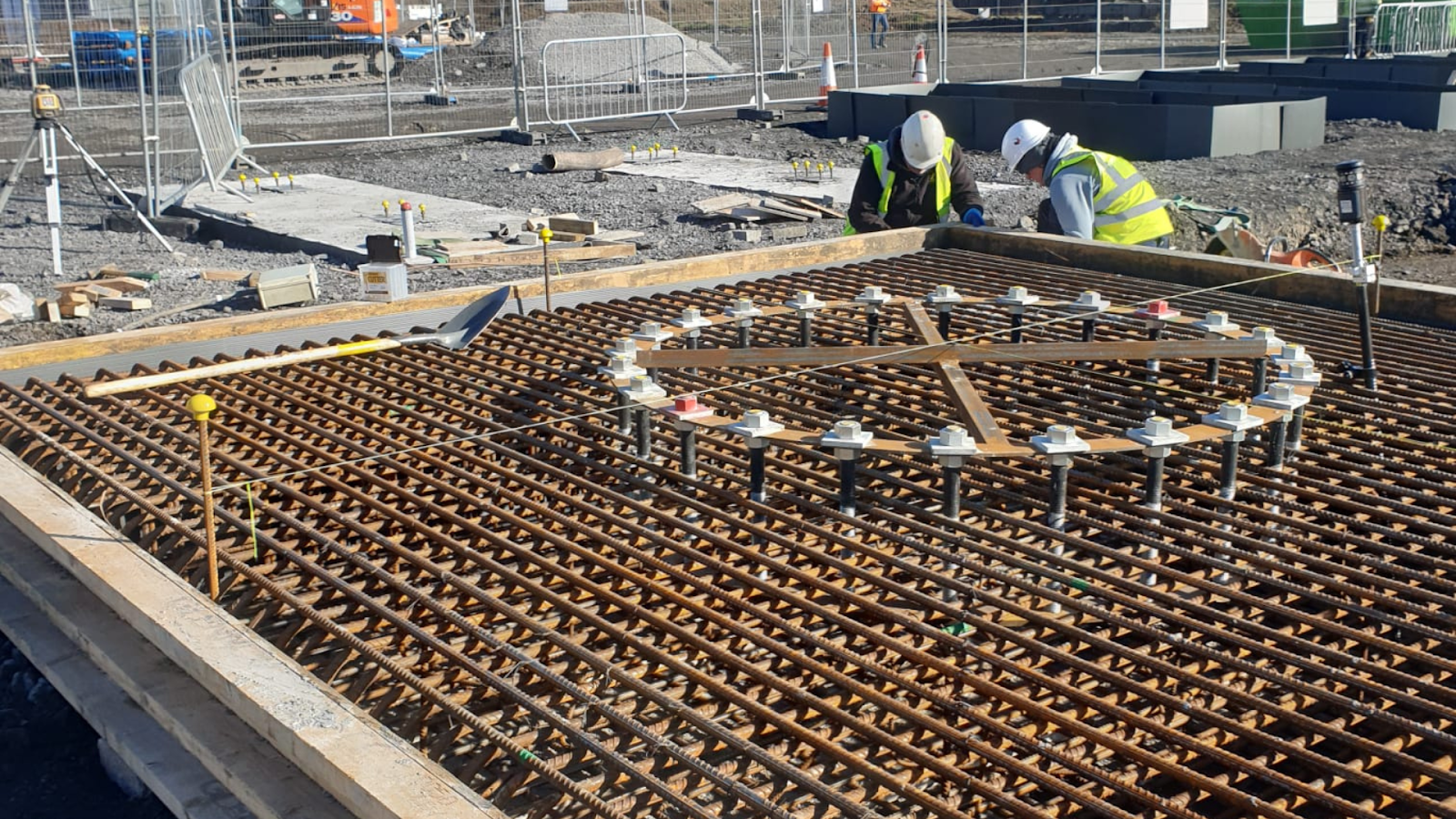 Construction site with two workers in background.