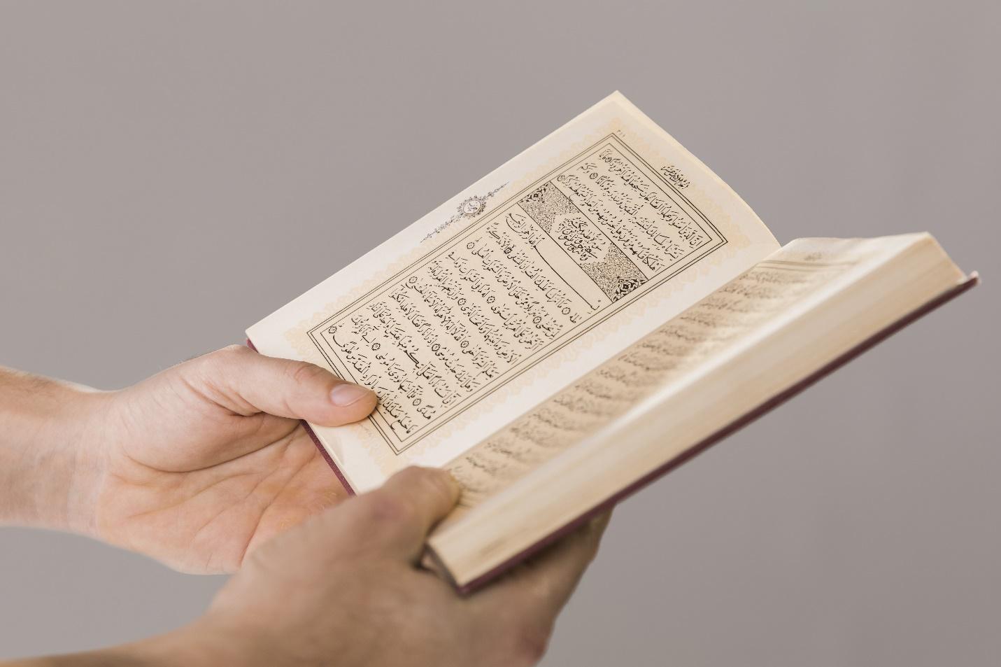 C:\Users\ASUS\Downloads\quran-being-held-hands-close-up.jpg