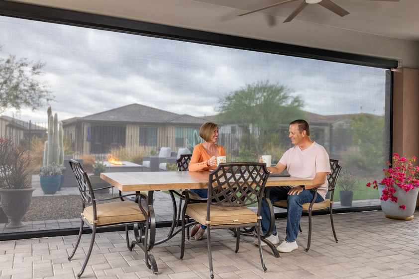 Couple sitting on back porch with UV solar shades