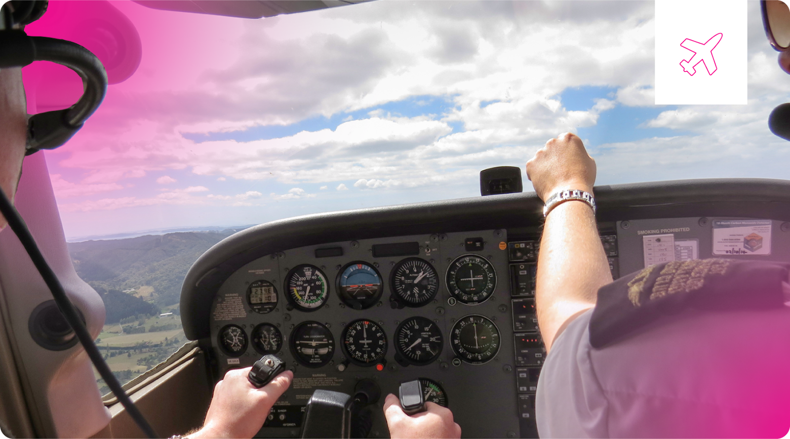 An instructor guides a student pilot in the cockpit of a small airplane.