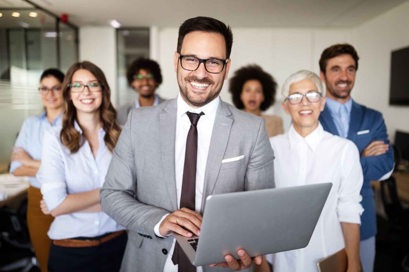 Business people gather in a meeting room for a group picture. 