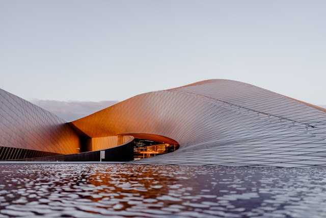 A building getting curved into the ground level designed using parametric architecture principles