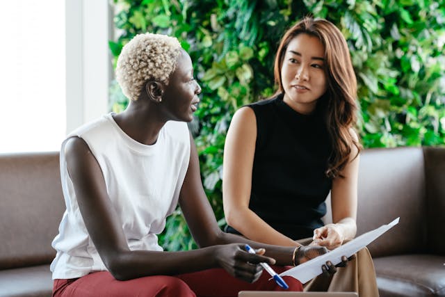 Two women sitting on a sofa, engaged in conversation