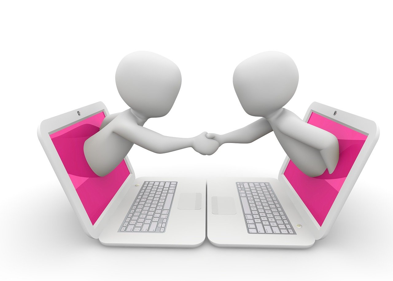 Illustration of two individuals emerging halfway out of their laptops, shaking hands.