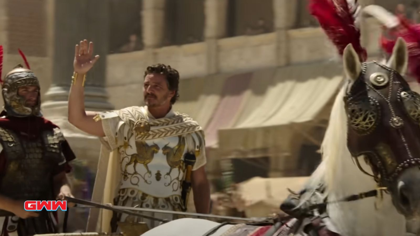 Marcus in a chariot, wearing Roman armor and raising his hand.