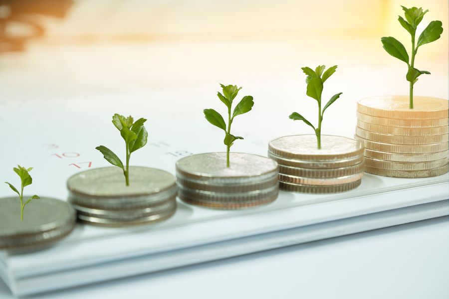 Coins with small plants growing on top, representing financial growth and investment.