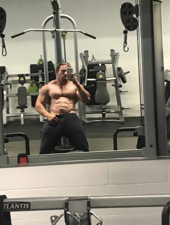 Cody Mac taking a shirtless gym mirror selfie showing off his thick muscled chest