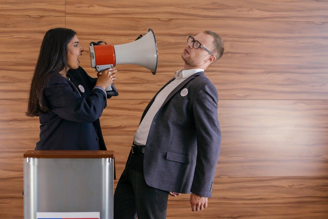 Free Woman Shouts on Man Using Megaphone Stock Photo