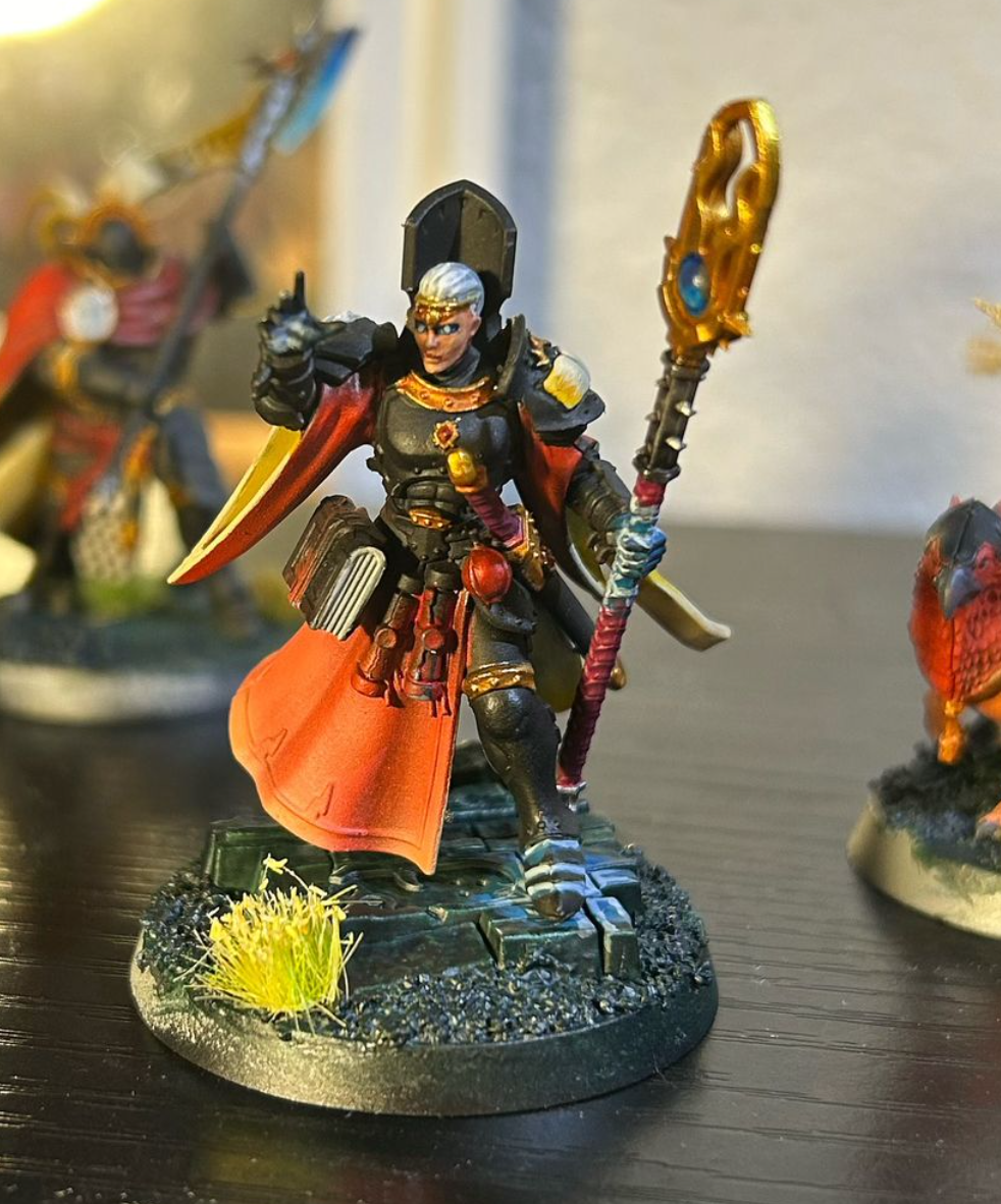 A toy figurine of a person holding a staff Description automatically generated