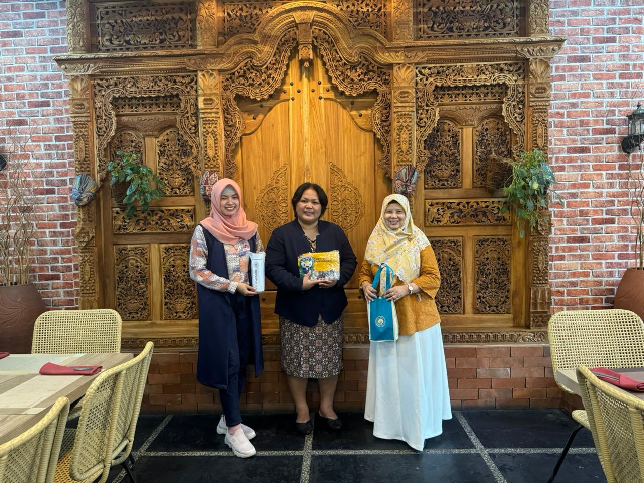 A group of women standing in front of a wood door

Description automatically generated