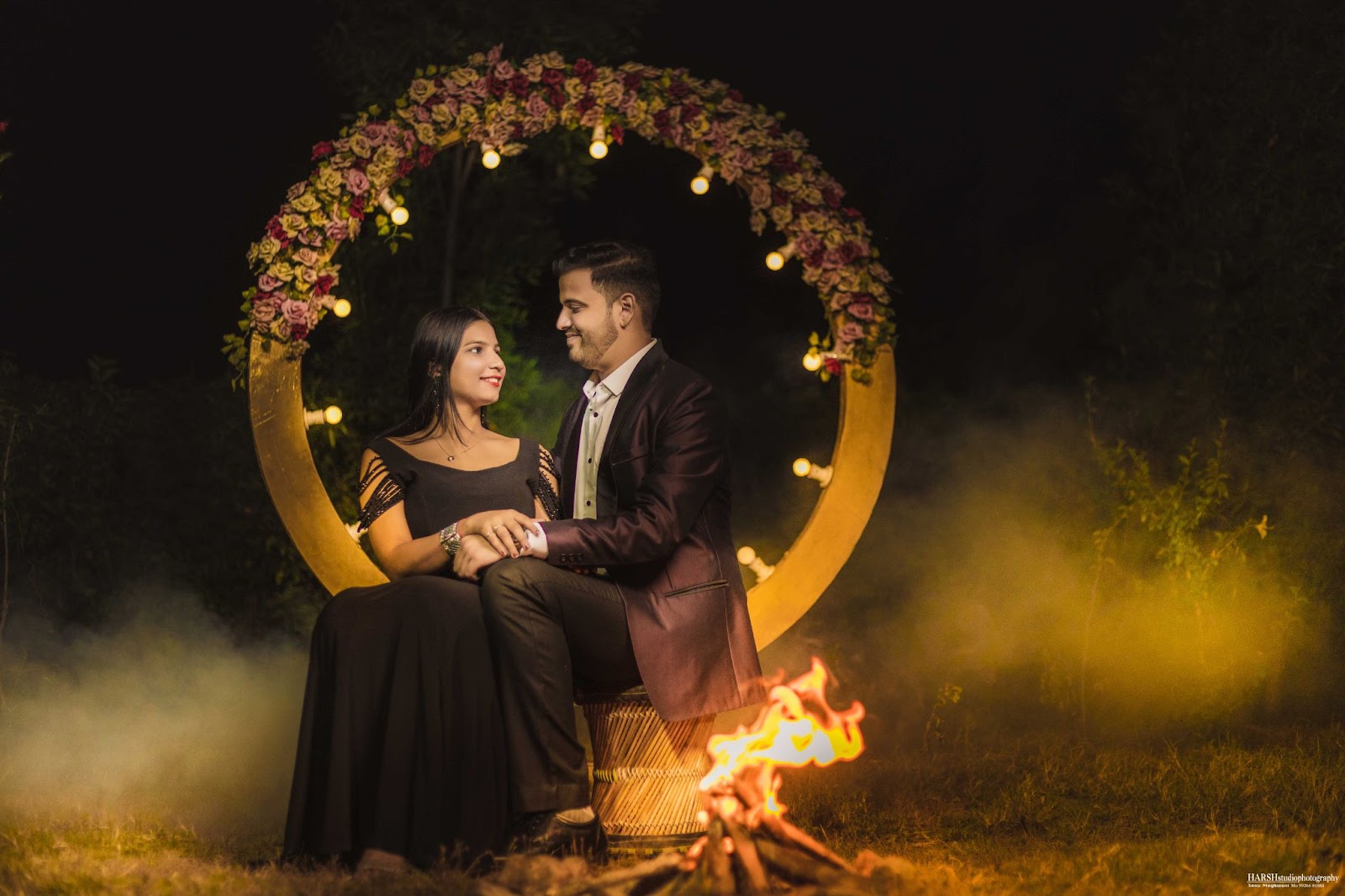 Romantic pre-wedding shoot with couple sitting by a campfire, captured by Harsh Studio Photography in 2024. Location: Indore, Madhya Pradesh, India.