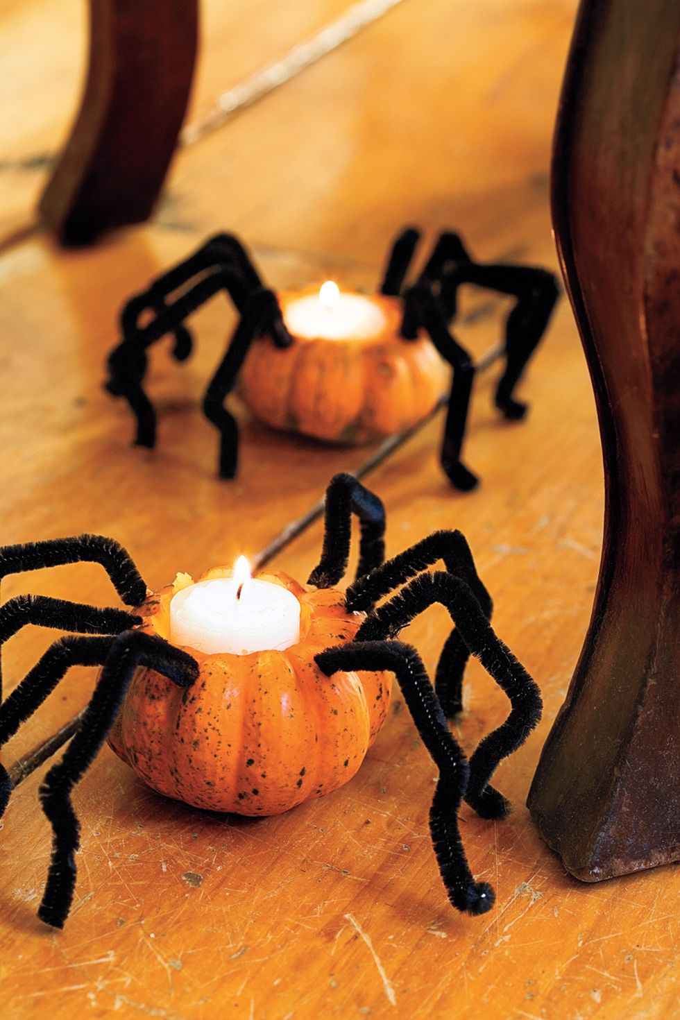 diy halloween decorations, small pumpkins with candles inside and spider legs