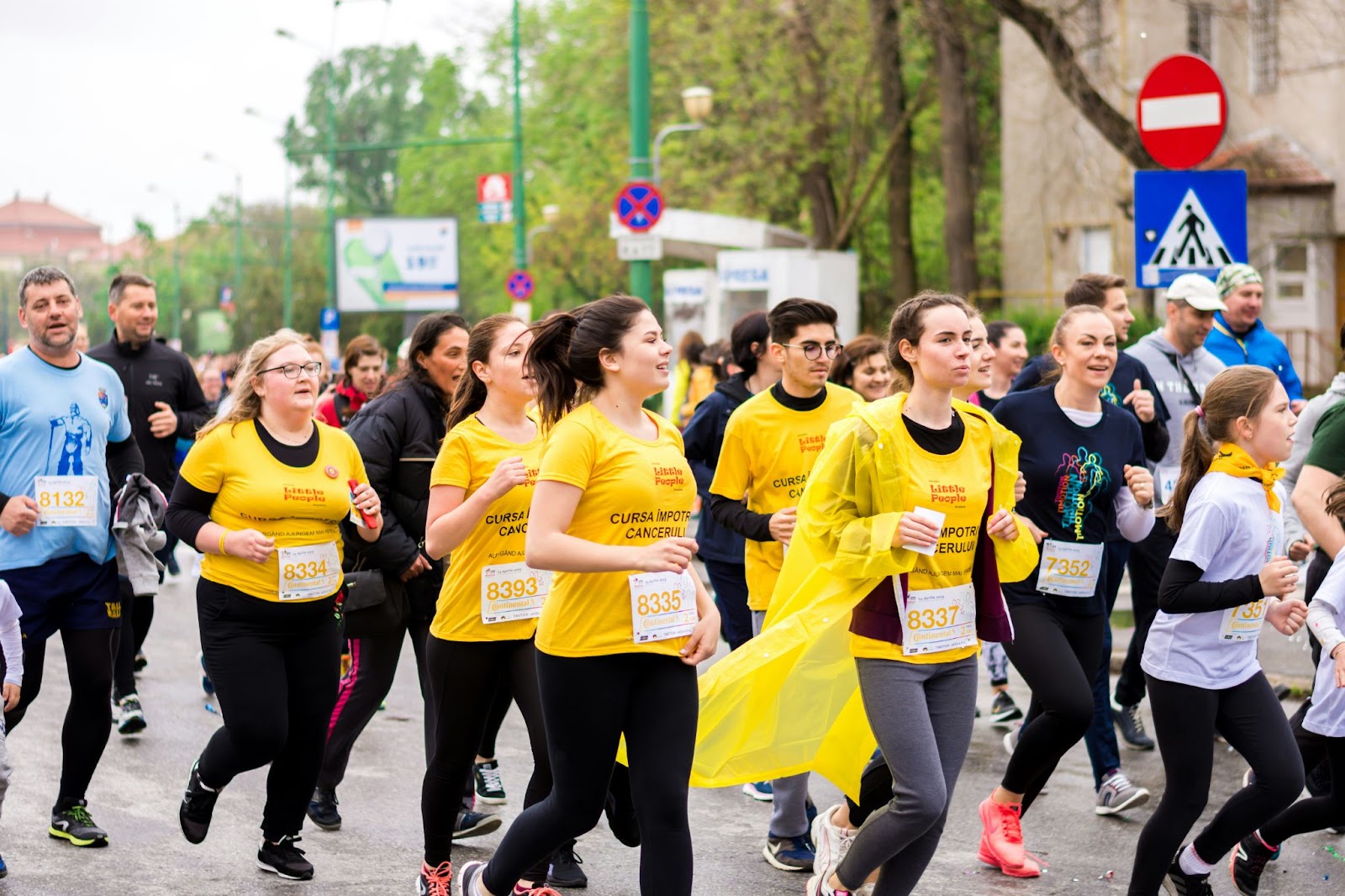 A group of people wearing matching yellow printed t-shirts for a charity run.