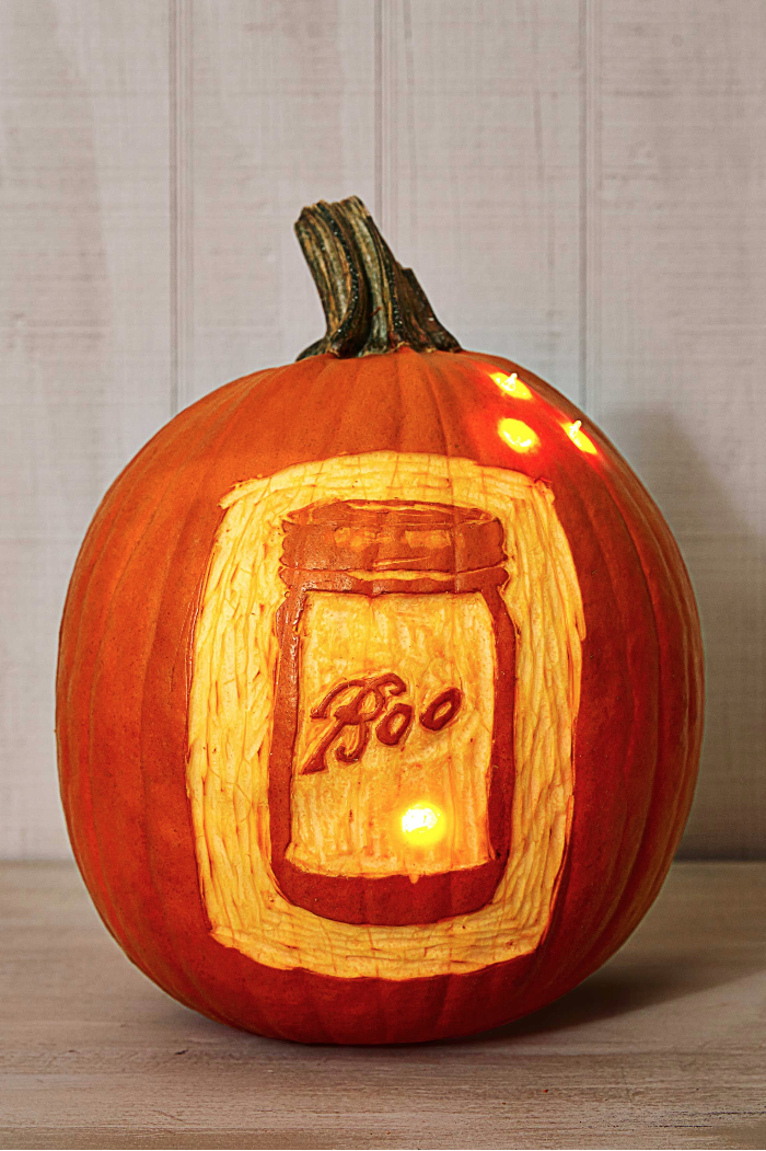 pumpkin carving ideas, pumpkin carved with a mason jar in the front