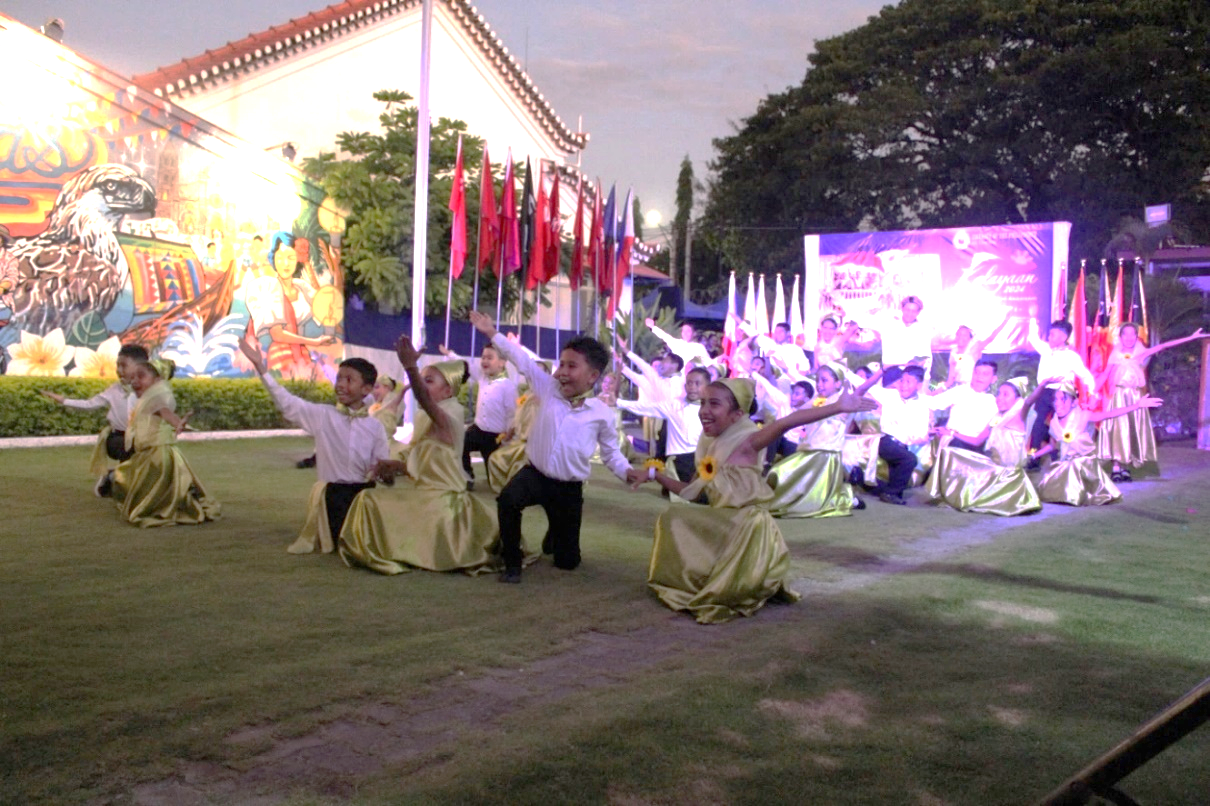 A group of children in formal attire performing on a lawnDescription automatically generated