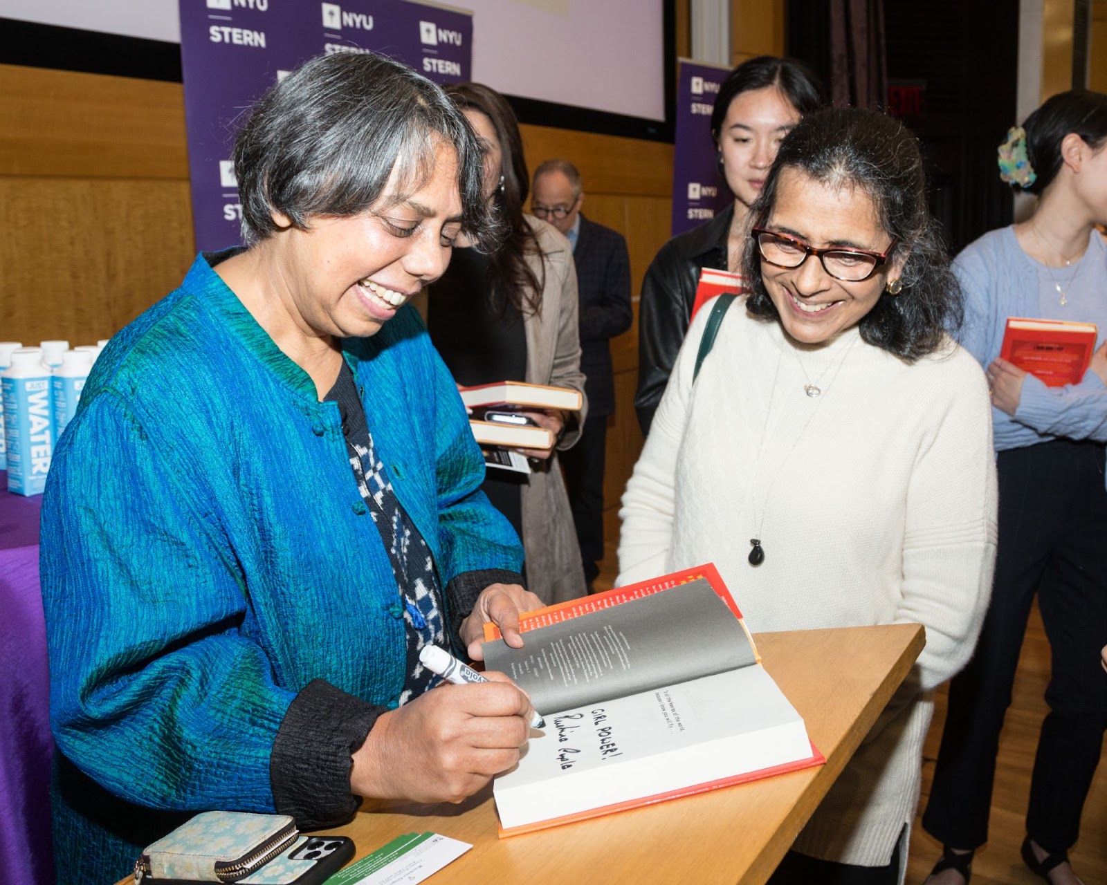 Ruchira Gupta signing a copy of her debut novel, I Kick and I Fly, for an audience member
