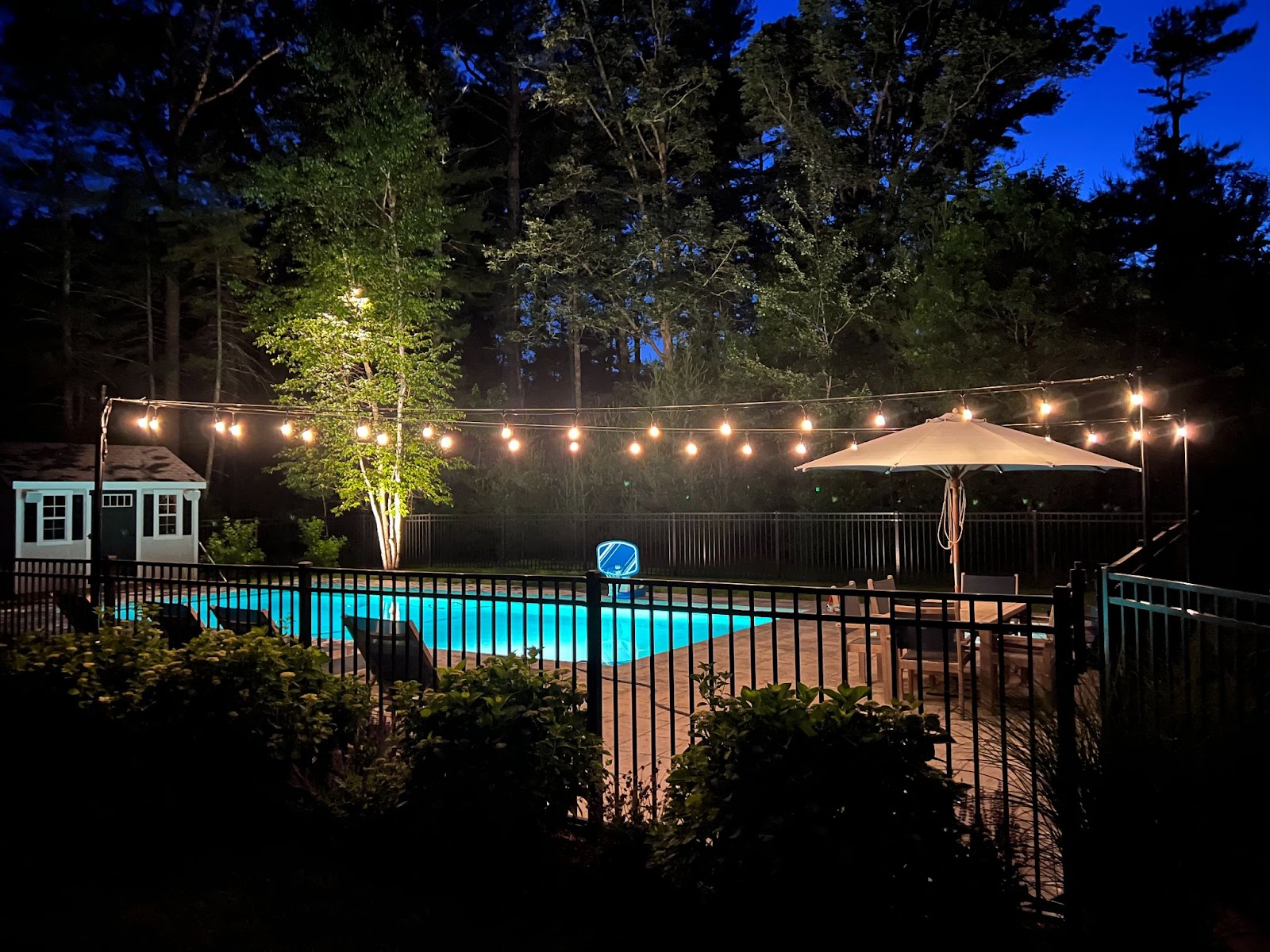 an outdoor lighting designer creates a relaxed mood with lights by the pool