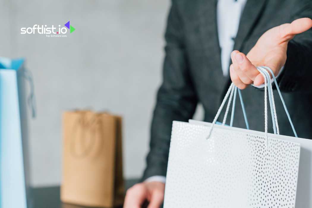 Man in suit offering shopping bag, focus on hand and bag