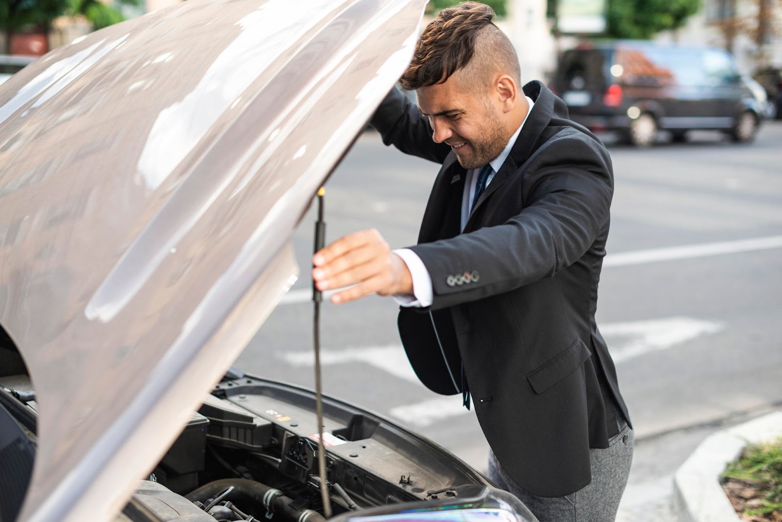 Man inspecting a car engine with the hood open