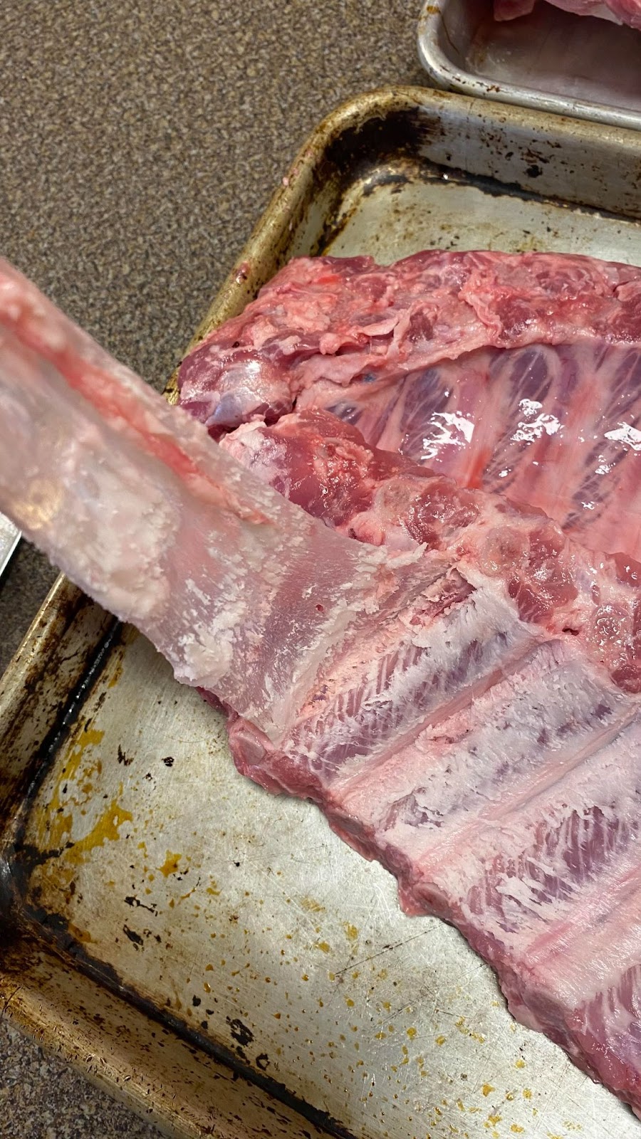 Removing the membrane from a slab of ribs before grilling