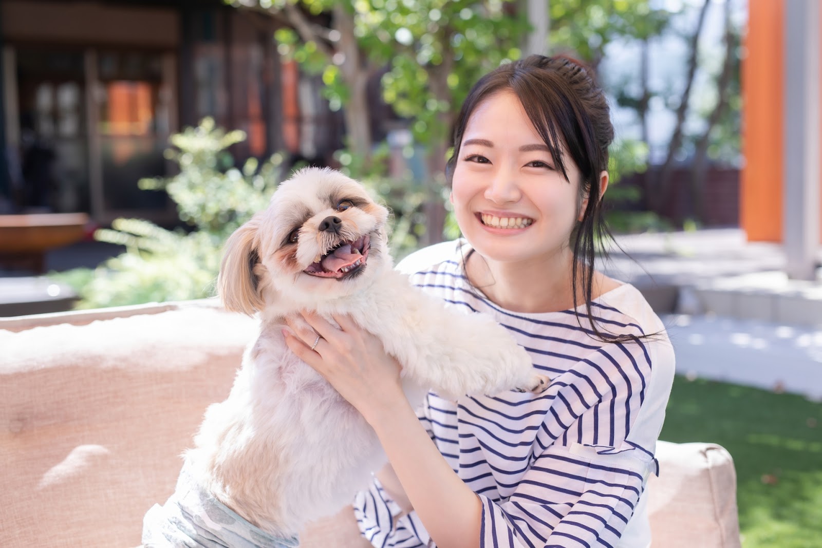 ドッグランで愛犬と写真を撮る女性