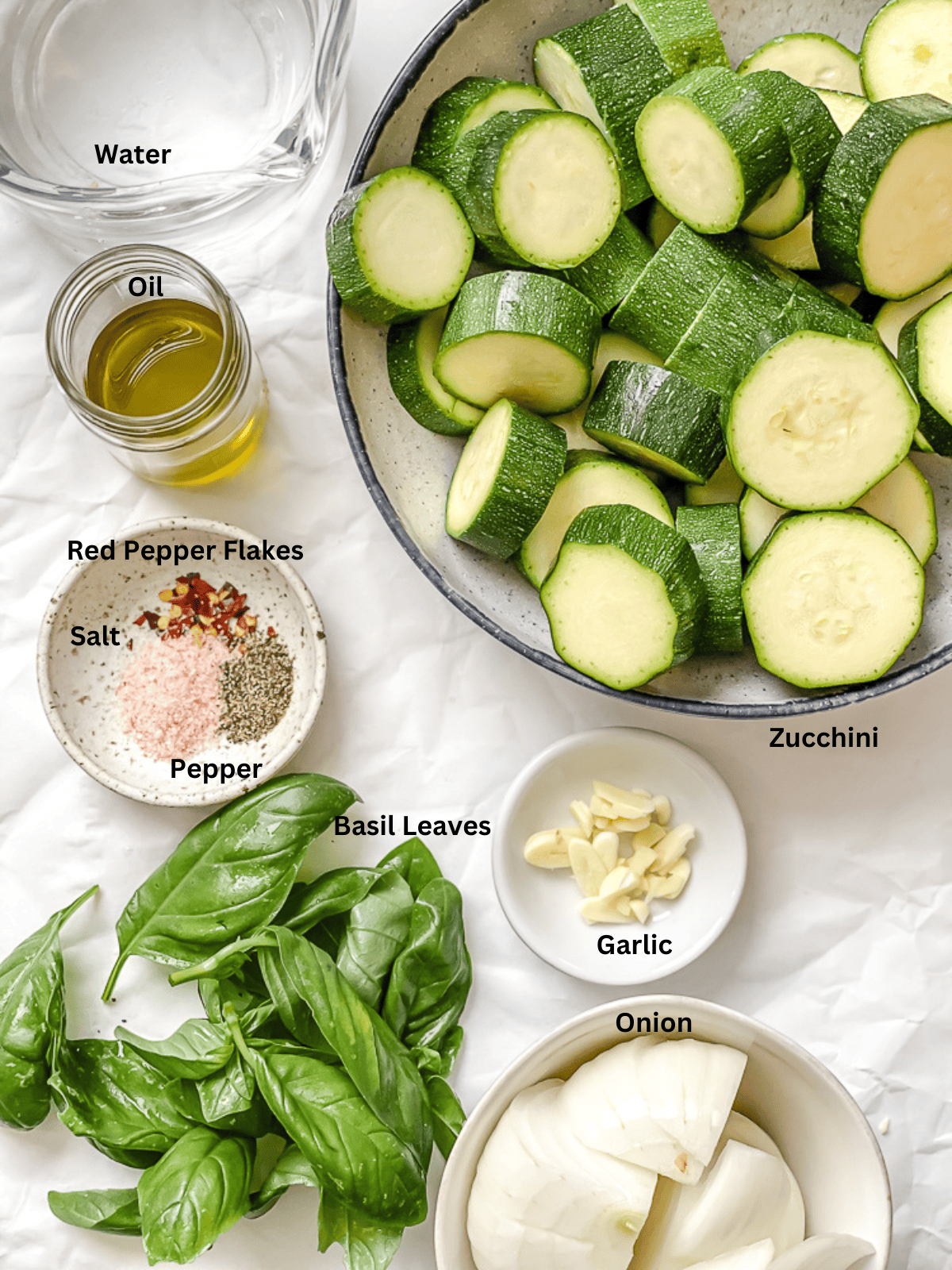 Ingredients for vegan zucchini soup in individual bowls with labels.