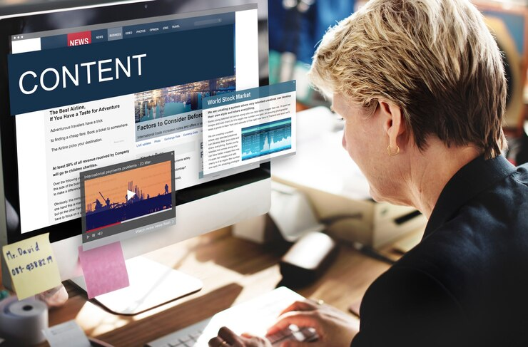 A person working at a computer with floating screens showing news articles and other visuals