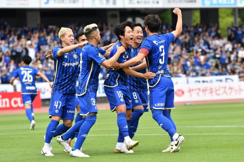 A group of men in blue uniforms celebrating

Description automatically generated