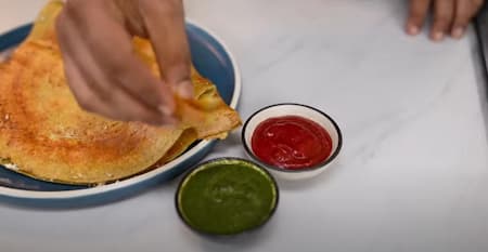Serving the crispy high protein chilla hot with mint chutney and tomato ketchup.
