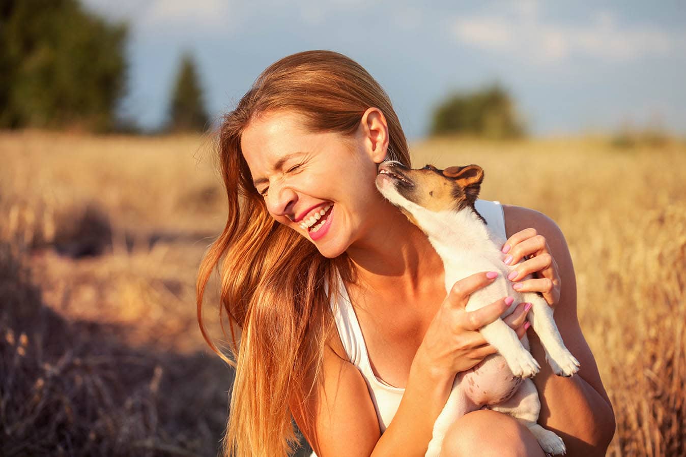 Perro lamiendo oreja de mujer