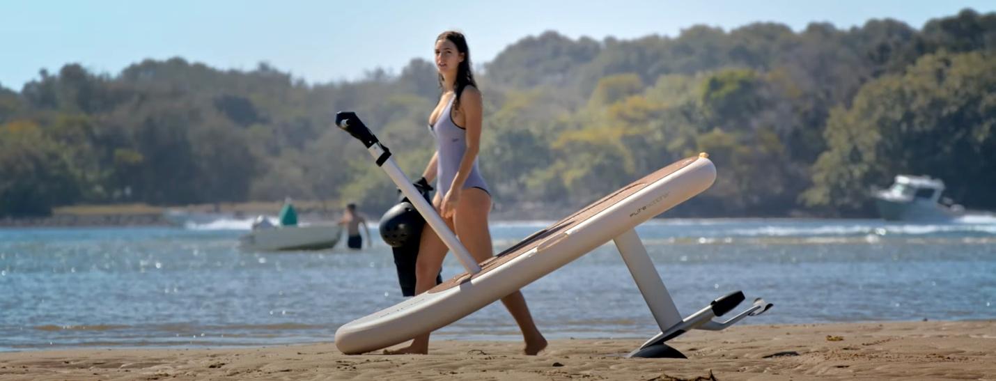 A person walking on a beach with a surfboard

Description automatically generated