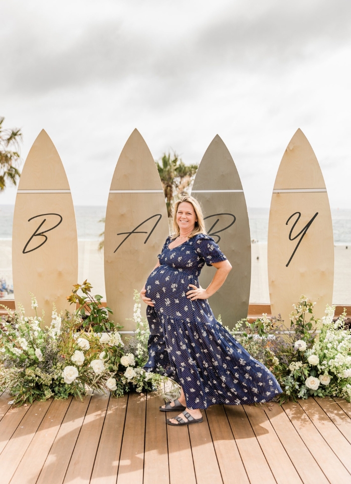 pregnant woman standing in front of baby on surfboards