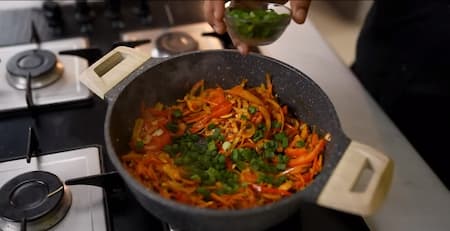 Mixed vegetables and spices cooking in a pot.