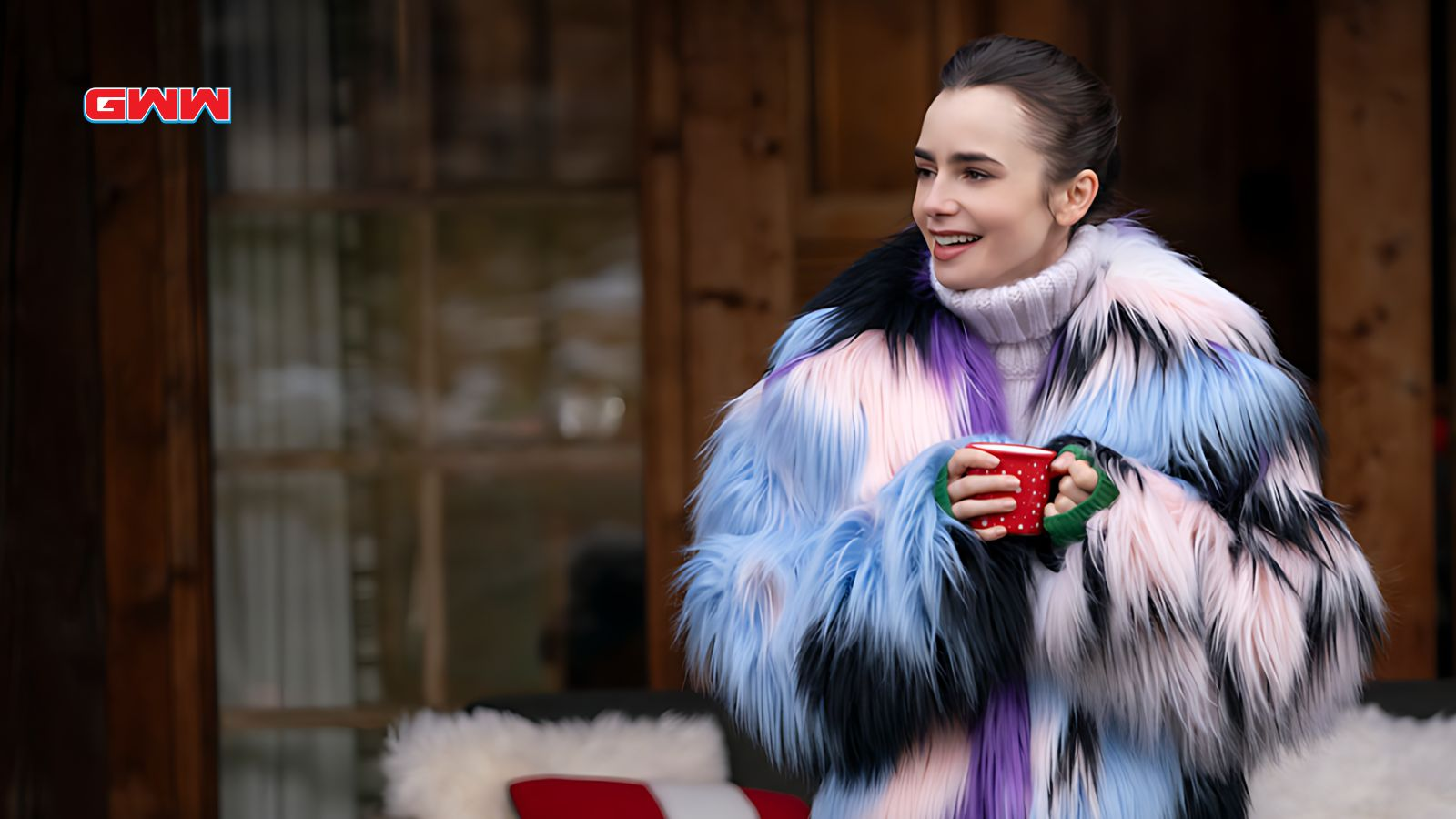 Emily in colorful fur coat holding a red mug outside.