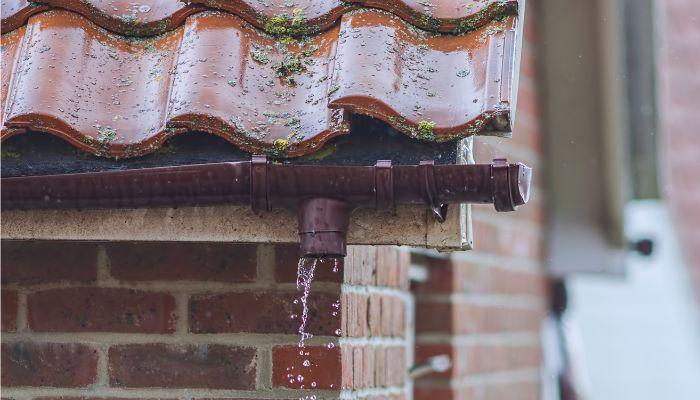 A rain gutter with water coming out of it

