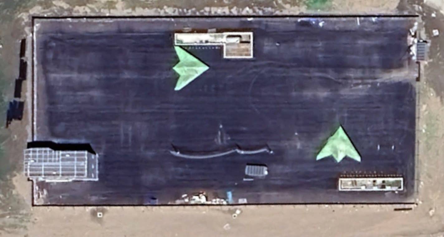 A close-up look at the GJ-11 mockups at the apron area at the site on Changxing Island. The three structures, as well as what may be a jet blast deflector, are visible. It's possible the gray structure at the left could be intended as a stand-in for the island on a carrier or big deck amphibious assault ship. <em>Google Earth</em>