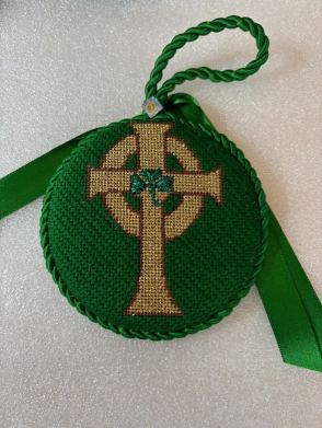 A green cross with a green ribbon

Description automatically generated