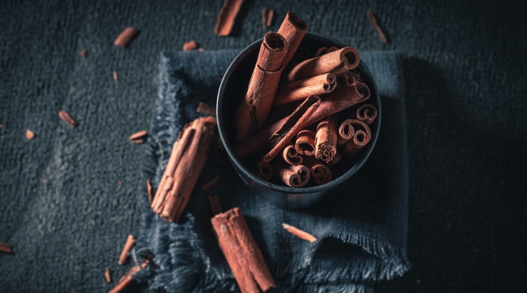 Cinnamon in a cup on a dark table