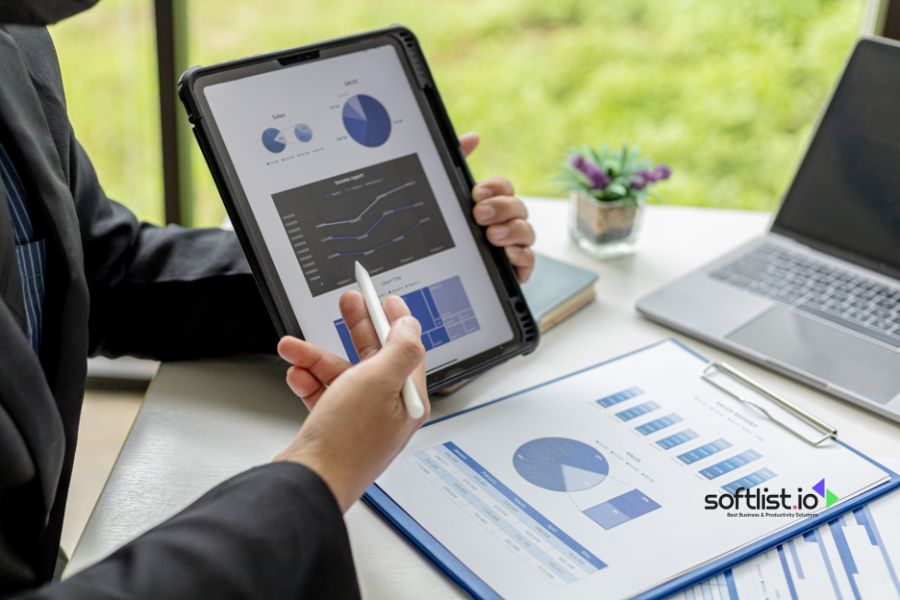 Businessperson analyzing data charts on a tablet and printed documents