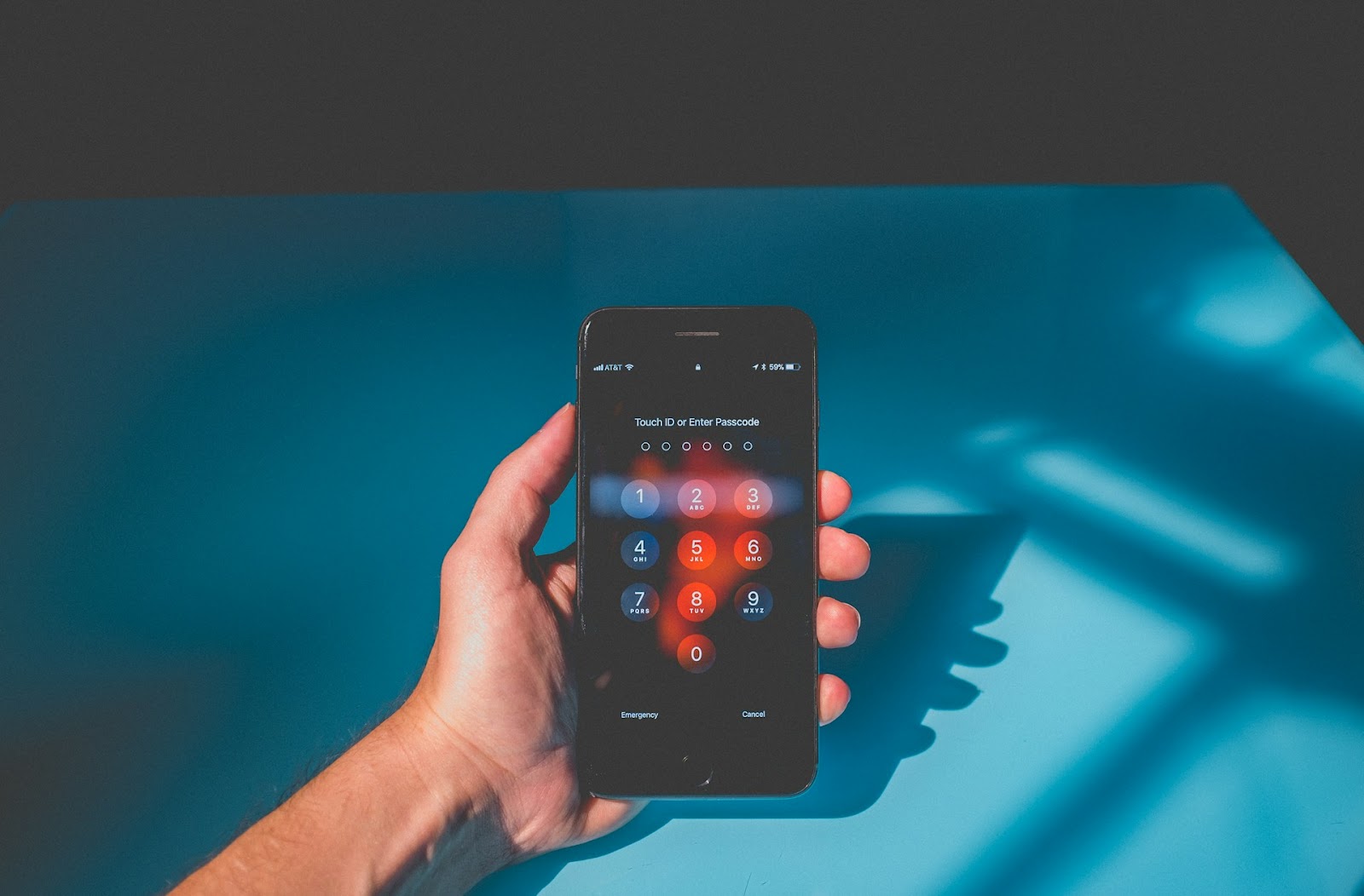 A person holding a smartphone with a fingerprint scanner, demonstrating how to use the scanner for phone security.