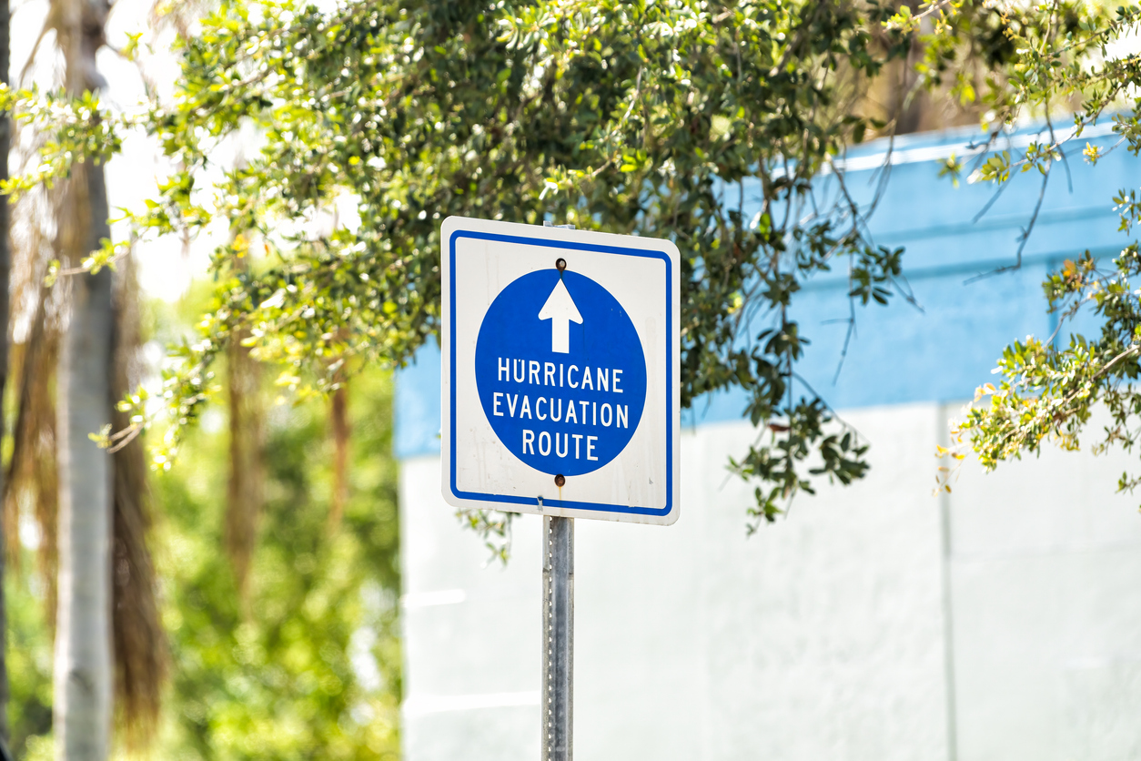 A sign reads “Hurricane Evacuation Route” on a Florida street during the day.