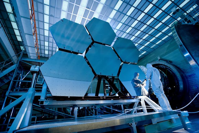 A scientist stands beside a large space telescope, ready to explore the mysteries of the universe.