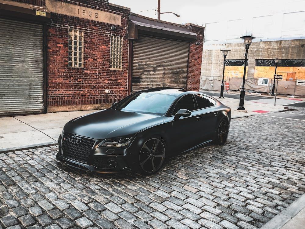 Free Black Audi A-series Parked Near Brown Brick House Stock Photo