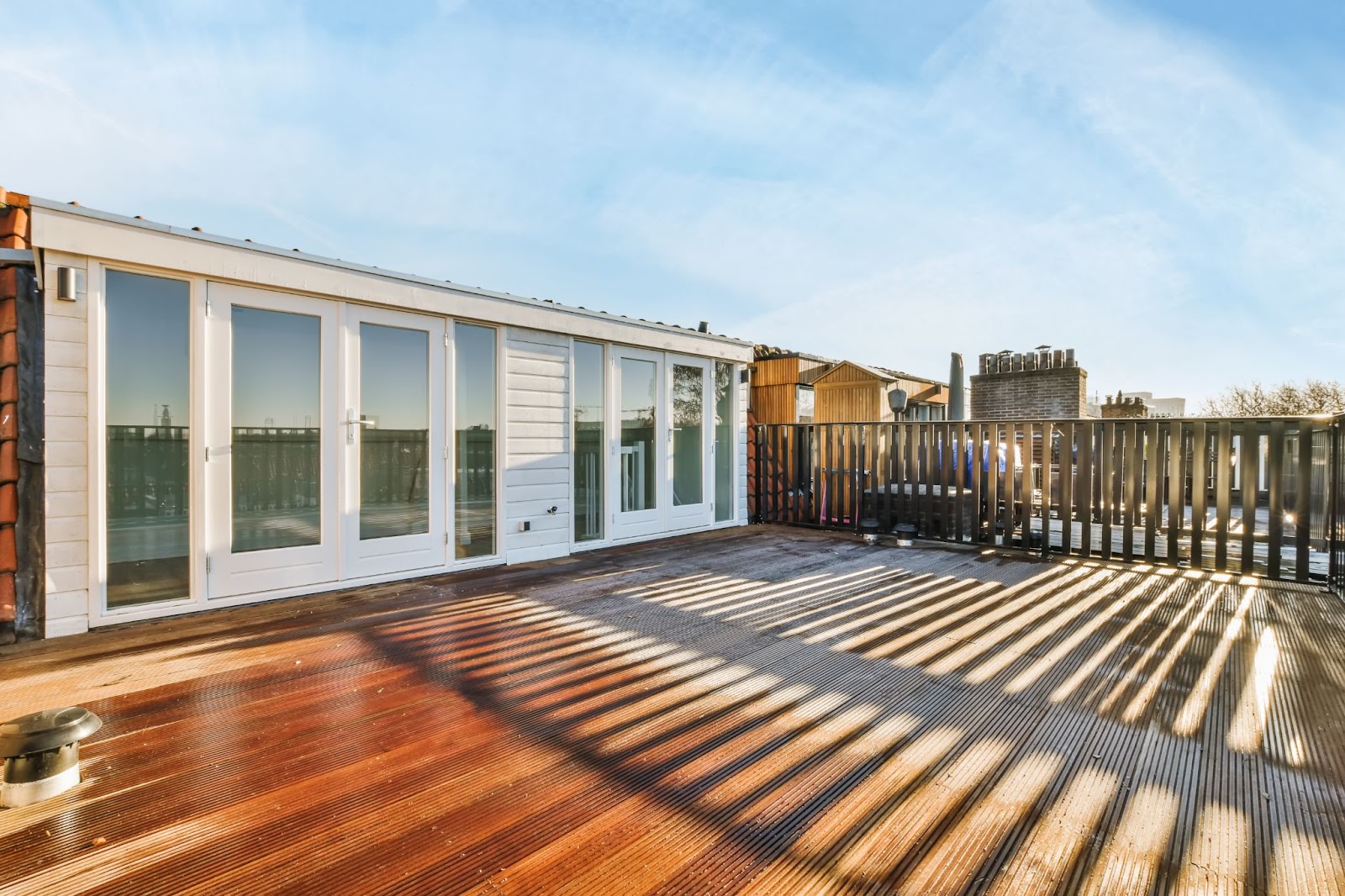 A large balcony with a wooden floor. 